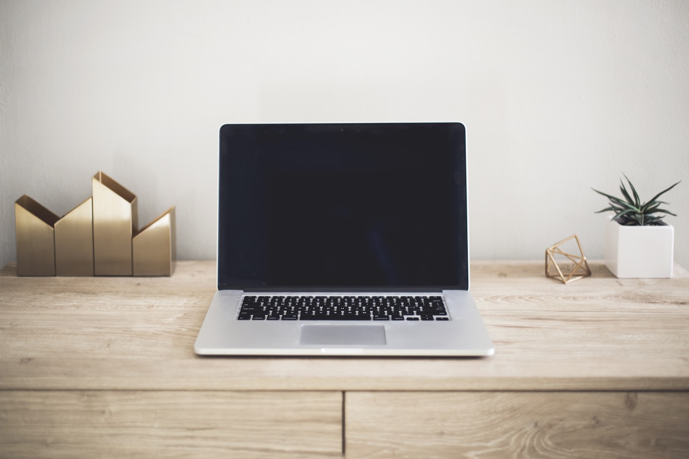 Illustrative stock photo: laptop on a minimal desk (not our showroom).