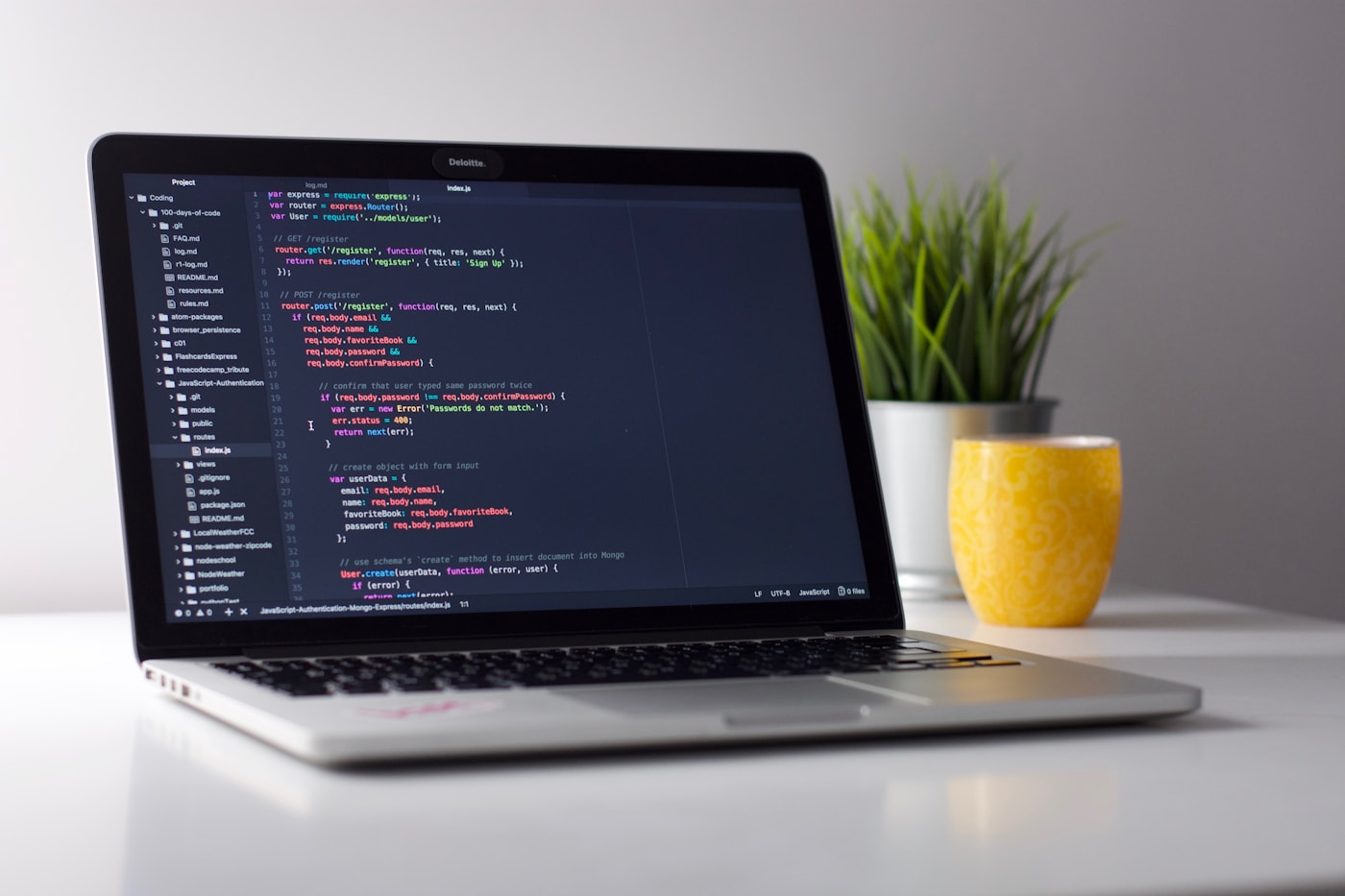Illustrative stock photo: open laptop on a desk with code on screen; suggests a repair or build workspace (not our shop).
